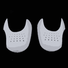 a pair of white shoe protectors on a black surface