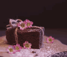 a brownie with pink flowers and powdered sugar on it