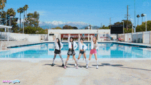 a group of girls are standing in front of a swimming pool with a sign that says bulldogs on it