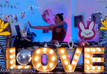 a woman dancing in front of a sign that reads love