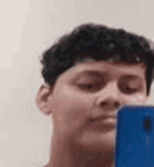 a young man is taking a selfie with a cell phone .