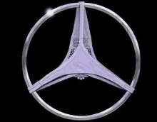 a pair of purple underwear is sitting inside of a mercedes benz logo on a black background .