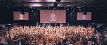 a large group of people are gathered in front of a large screen that says ' i am a winner '