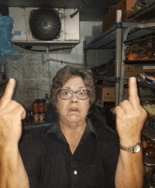 a woman wearing glasses and a watch is making a middle finger gesture