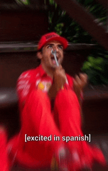 a blurry picture of a man in a red shirt and hat with the words excited in spanish below him