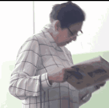 a woman with glasses is reading a book