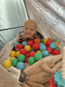 a baby is laying in a pile of plastic balls