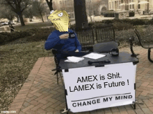 a man is sitting at a table with a sign that says amex is shit lamex is future