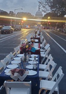 a long table with a vase of flowers on it sits on the side of a street in front of the capitol building