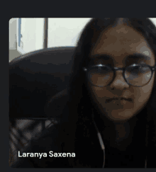 a woman wearing glasses has the name laaranya saxena on the bottom right