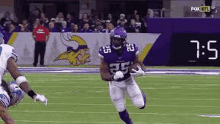 a football player is running with the ball on the field .