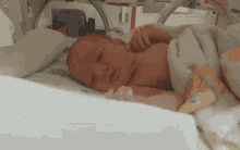 a newborn baby is wrapped in a blanket and sleeping