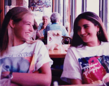 a woman wearing a t-shirt that says goodbye sits next to another woman