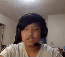 a young man wearing headphones and a microphone is talking on a video call .