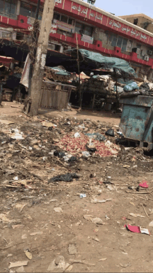 a pile of garbage in front of a building with arabic writing