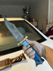 a person is holding a knife with a blue handle