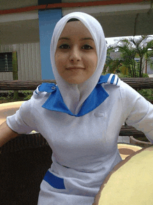 a woman wearing a white hijab and a white shirt