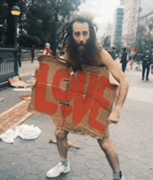 a bearded man is holding a cardboard sign that says love