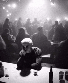 a man sitting at a table in a crowded room