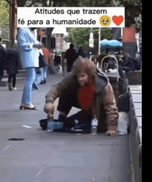 a sign that says atitude que trazem fe para a humanidade is above a homeless man