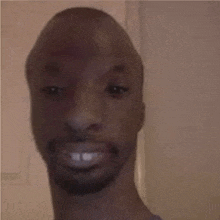 a close up of a man 's face with a beard and a smile .