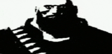 a black and white silhouette of a man with a beard and sunglasses .