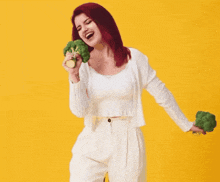 a woman with red hair singing into a broccoli head