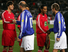 soccer players shaking hands on a field with one wearing the number 17