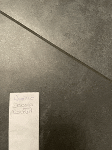 a piece of paper on a tile floor says nostic daaya rockid