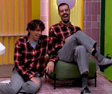 two men wearing plaid shirts are laughing together