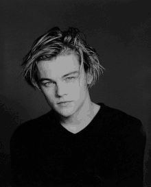 a black and white photo of a young man with a messy haircut