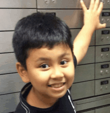 a young boy stands in front of a row of lockers with numbers 1237 and 1235 on them