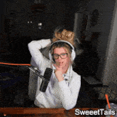 a woman wearing headphones and glasses is sitting in front of a microphone with sweettails written on the bottom