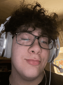 a young man wearing glasses and headphones with a microphone