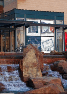 a waterfall in front of a miller 's restaurant