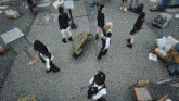 a group of women are standing in a circle with one carrying a bouquet of flowers and another holding a gun