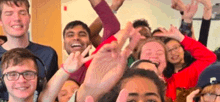 a group of young people are posing for a picture and making a peace sign .