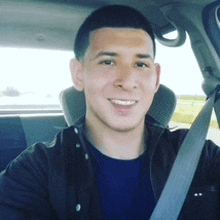 a man is smiling while sitting in a car with a seat belt