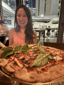 a woman sits at a table with a pizza and a sign that says exit