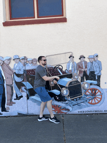 a man stands in front of a ford car painting