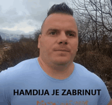 a man in a blue shirt with hamdija je zabrunut written on it