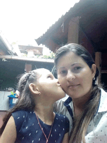 a little girl kisses a woman on the cheek