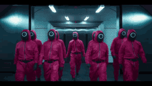 a group of people in red jumpsuits with circle masks