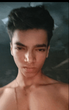 a shirtless young man taking a selfie with his eyes closed