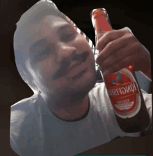 a man holds a bottle of kingfisher beer