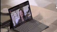 a laptop is open to a video call with a woman