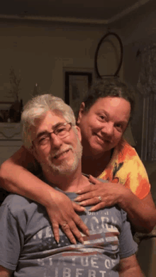 a woman is hugging a man wearing a shirt that says true liberty