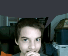 a young man is looking at the camera with a brute trash can in the background