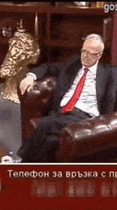 a man in a suit and tie sits on a couch