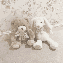 a brown teddy bear and a white bunny are sitting next to each other on a carpet